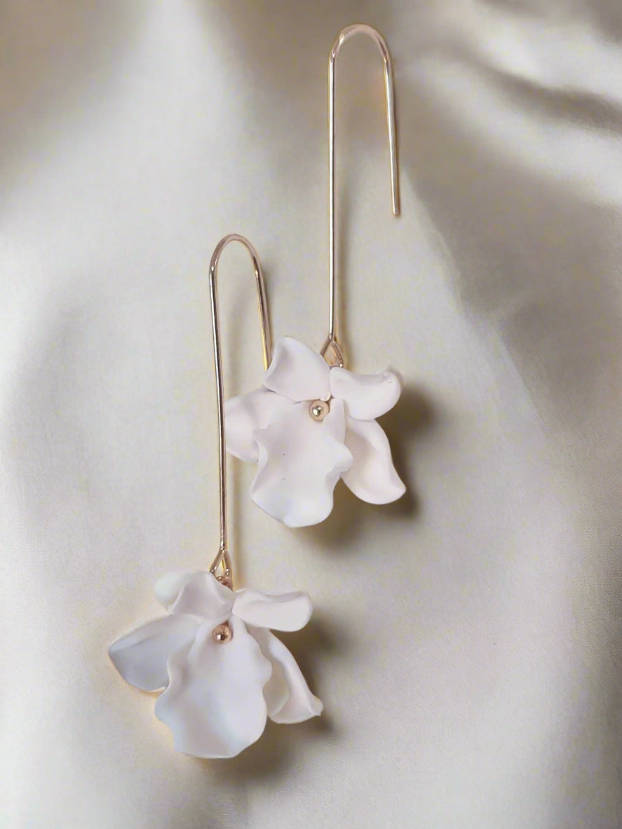 A pair of ivory clay floral bridal earrings with gold accents, displayed against a white background.